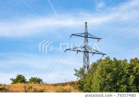 Energy and electricity industry, power lines, electrical equipment and high-voltage wires on the mountain near the forest against the background of nature and the sky Energy and electricity industry, power lines, electrical equipment and high-voltage wires on the mountain near the forest against the background of nature and the sky 79357480