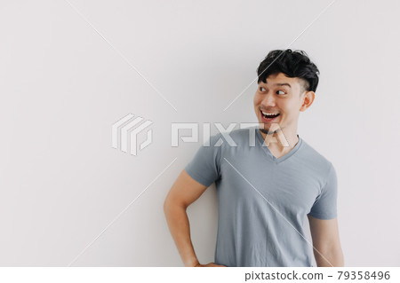 Happy face of Asian man look at an empty space isolated on white wall 79358496