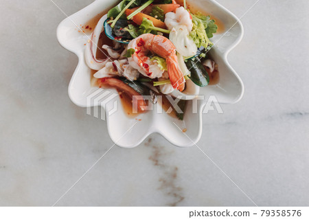 Thai seafood spicy salad served in a fancy bowl. 79358576