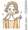 Middle-aged woman holding a toothbrush and signing OK 79360044