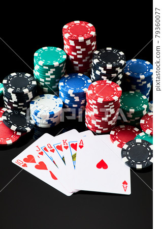 Stack of Casino gambling chips and cards isolated on black reflective background 79360077