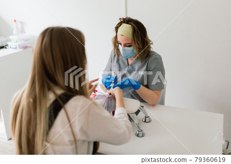 Female manicure master in a beauty salon work with hands of the client Female manicure master in a beauty salon work with hands of the client 79360619