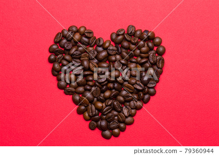 Grains of coffee in the form of heart on a red background Grains of coffee in the form of heart on a red background 79360944
