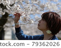 一個年輕女子盯著櫻花，若有所思 79362026