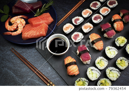Close-up of fish sushi and vegetable sushi with chopsticks, soy sauce and a plate with ingredients. Oriental food Close-up of fish sushi and vegetable sushi with chopsticks, soy sauce and a plate with ingredients. Oriental food 79362454