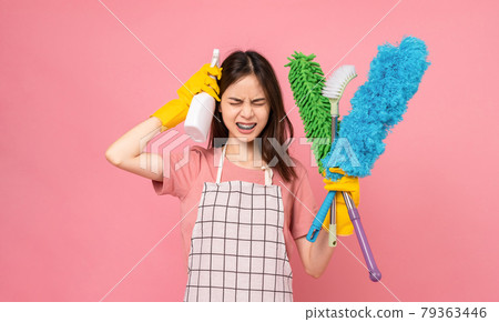 woman wearing apron with yellow rubber gloves and holding bucket of cleaning supplies. 79363446