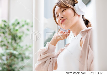 戴著耳機聽音樂的年輕女人 戴著耳機聽音樂的年輕女人 79363476