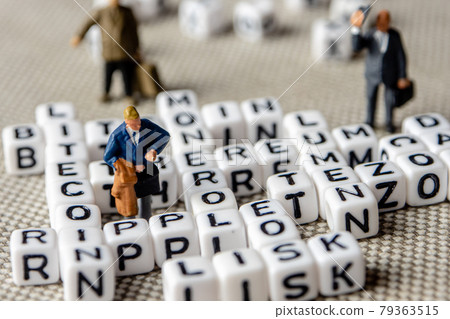 set of popular crypto coins words forming thematical crossword made of white cubes with black capital letters and miniature businessmen figurines having a team meeting 79363515