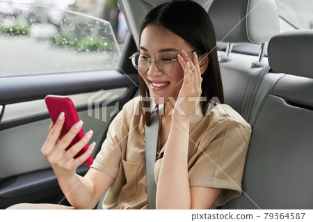 Woman looking at the smartphone screen and smiling toothy while having video chat 79364587