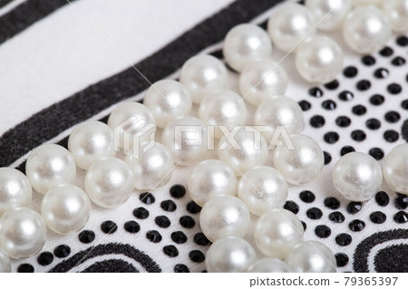 Beautiful pearl decoration in the form of white balls on stylish clothes, macro. Fashionable Beautiful pearl decoration in the form of white balls on stylish clothes, macro. Fashionable 79365397