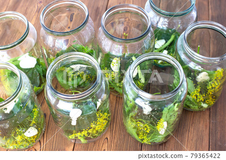 Jars with spices, garlic and pickle for preserving cucumbers. Jars with spices on a wooden background, preservation for the winter Jars with spices, garlic and pickle for preserving cucumbers. Jars with spices on a wooden background, preservation for the winter 79365422