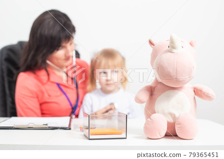 aucasian doctor pediatric therapist listens with a stethoscope to the lungs of a child who has a cough. Concept for the treatment of bronchitis and pneumonia in children 79365451