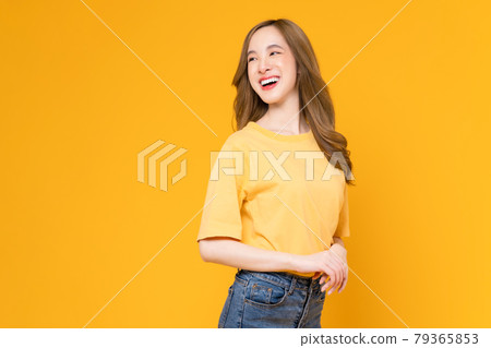 Studio shot of cheerful beautiful Asian woman in t-shirt and stand on yellow background. 79365853