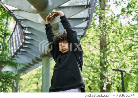 Man wearing sports clothes warming up before jogging on the street Man wearing sports clothes warming up before jogging on the street 79366174
