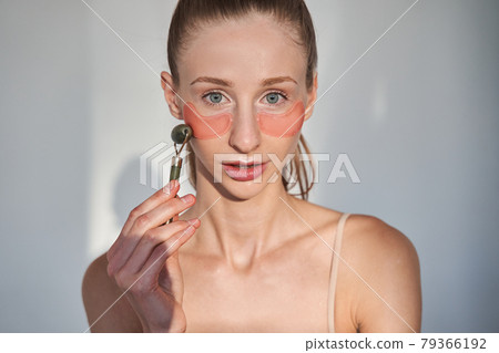 Female with vitiligo skin wearing cosmetic mask under eyes for preventing wrinkles 79366192