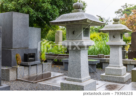 Rainy day cemetery, black tombstones and white lanterns 79366228