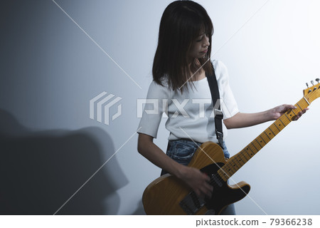 A woman playing the guitar A woman playing the guitar 79366238