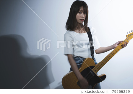 A woman playing the guitar A woman playing the guitar 79366239