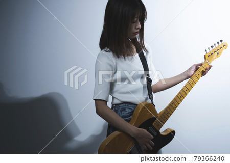 A woman playing the guitar A woman playing the guitar 79366240