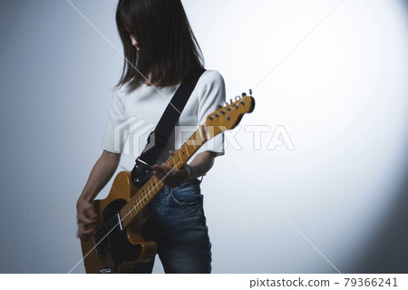 A woman playing the guitar 79366241