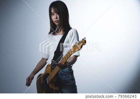 A woman playing the guitar 79366243