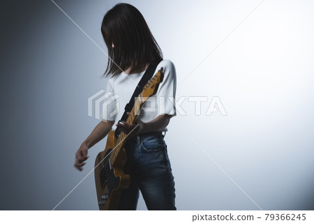A woman playing the guitar 79366245