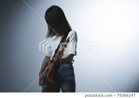 A woman playing the guitar 79366247