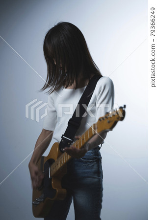 A woman playing the guitar A woman playing the guitar 79366249