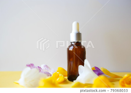 natural serum among freesia flowers on gray background natural serum among freesia flowers on gray background 79368033