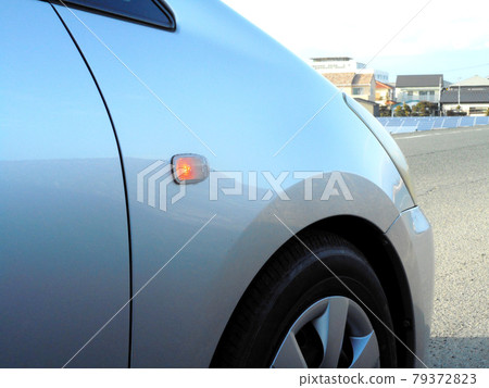 Turn signal attached to the fender of the car (lit) 79372823