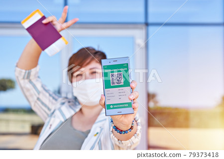 Happy woman holding smartphone displaying on app mobile valid digital vaccination certificate for Covid-19. Immunity vaccine passport, vaccination certificate, health passport for new normal travel Happy woman holding smartphone displaying on app mobile valid digital vaccination certificate for Covid-19. Immunity vaccine passport, vaccination certificate, health passport for new normal travel 79373418