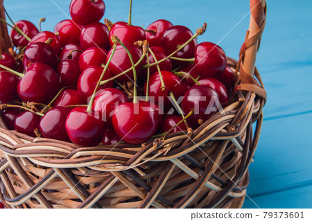 Close-up pile of fresh red cherries in the wicker basket. Close-up pile of fresh red cherries in the wicker basket. 79373601