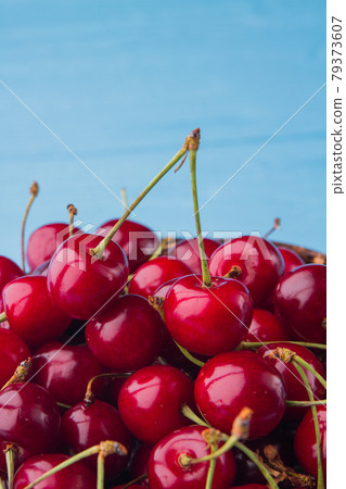 Close-up pile of fresh ripe cherries on blue background. 79373607