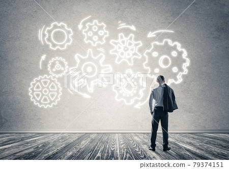 Cogwheel engine drawn on concrete wall as symbol for teamwork and cooperation Cogwheel engine drawn on concrete wall as symbol for teamwork and cooperation 79374151