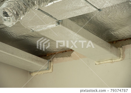 Ventilation pipes in silver insulation material on ceiling Ventilation pipes in silver insulation material on ceiling 79374787