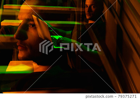 Cinematic portrait of handsome young man in neon lighted room, stylish male model indoors Cinematic portrait of handsome young man in neon lighted room, stylish male model indoors 79375271