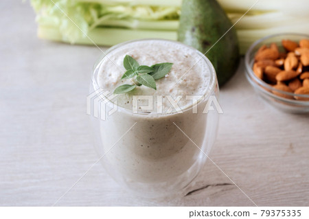 Green smoothie of celery and avocado with a basil branch in a glass. Fresh green vegetable 79375335