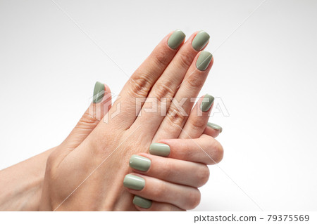 Beautiful womans hands with green nail. Fresh manicure isolated on white background Beautiful womans hands with green nail. Fresh manicure isolated on white background 79375569