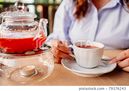 close-up. a woman pours tea into a white mug. serving hot drinks in a cafe close-up. a woman pours tea into a white mug. serving hot drinks in a cafe 79376243