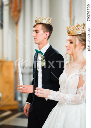 Bride and groom holding candles in church Bride and groom holding candles in church 79376709