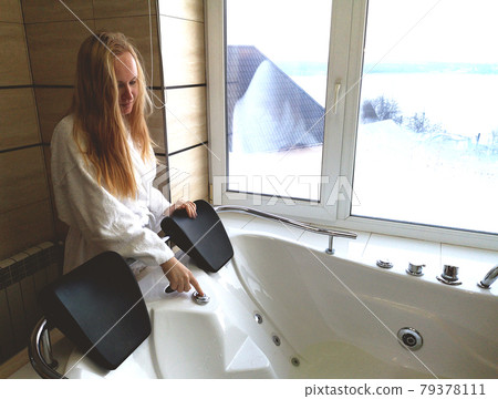 Beautiful woman in a hot tub. Jacuzzi in the hotel, panoramic view from the window in the bathroom 79378111