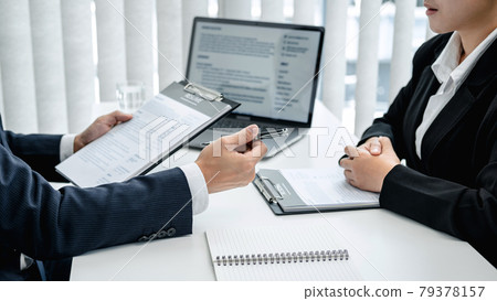 Man employer in suit is holding resume of applicant to reading her profile and asking candidate question Man employer in suit is holding resume of applicant to reading her profile and asking candidate question 79378157