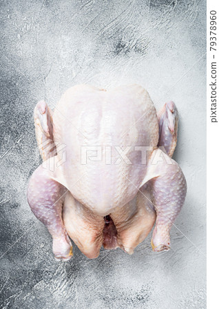 Raw free range whole chicken on a kitchen table. White background. Top view 79378960