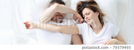 Young man and woman are sleeping on large white bed Young man and woman are sleeping on large white bed 79379493