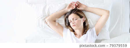 Young woman sleeping in white bed top view 79379559
