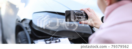Insurance agent taking pictures of wrecked car closeup 79379562