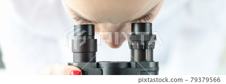 Woman scientist chemist looking through a microscope Woman scientist chemist looking through a microscope 79379566