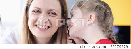 Little girl examining ear of doctor in clinic Little girl examining ear of doctor in clinic 79379579