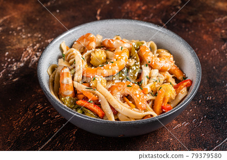 Chinese wok Stir-fry udon seafood noodles with shrimp prawns in a bowl. Black background. Top view 79379580