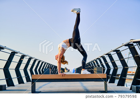 Pretty young woman doing yoga exercise on the nature in the morning. 79379598